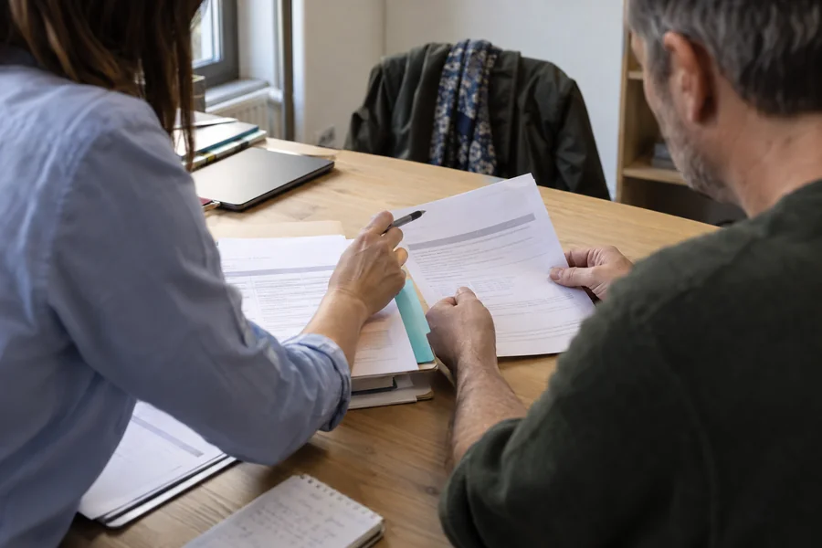 Deux personnes examinent ensemble un dossier administratif
